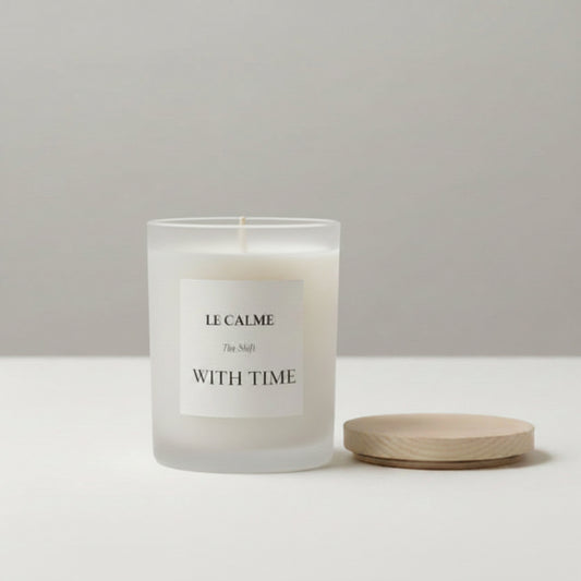 Candle labeled 'Le Calme' on a marble surface with a neutral background